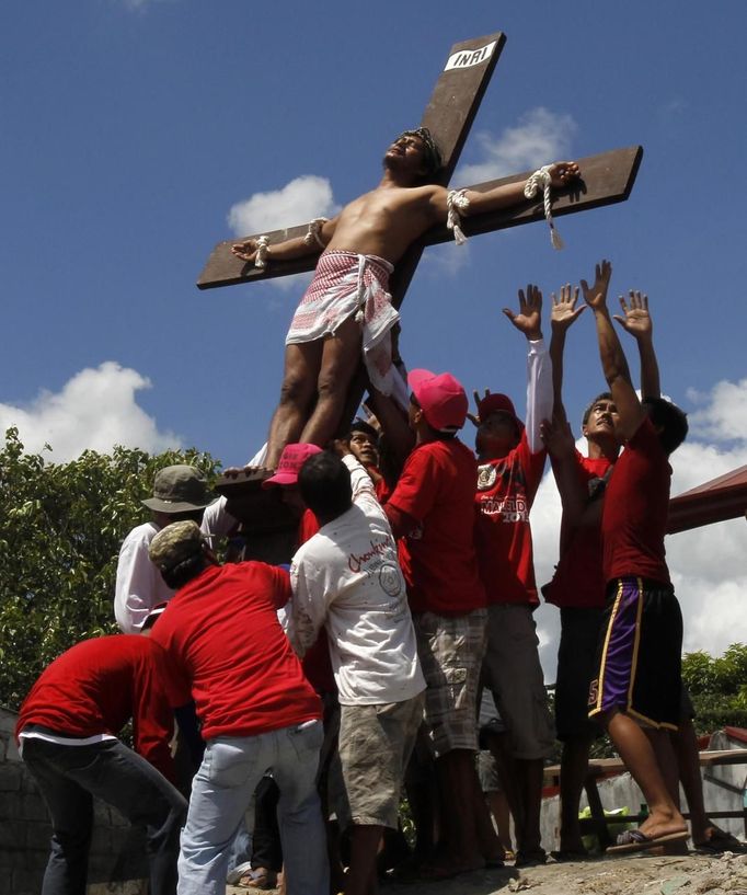 Rolly Pantajo, 58, who portrays Jesus Christ, is being laid down after he was nailed on a wooden cross during a Good Friday crucifixion re-enactment in San Juan village, Pampanga province, north of Manila March 29, 2013. The Roman Catholic church frowns on the gory spectacle held in the Philippine village of Cutud every Good Friday but that does nothing to deter the faithful from emulating the suffering of Christ and taking a painful route to penitents. Holy Week is celebrated in many Christian traditions during the week before Easter. REUTERS/Romeo Ranoco (PHILIPPINES - Tags: RELIGION SOCIETY) Published: Bře. 29, 2013, 4:57 dop.