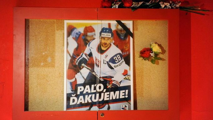 Slovenští fanoušci přinášejí květiny k plakátu Pavola Demitry na stadionu v Trenčíně