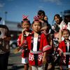 Children wave as they watch a parade in the Little Tokyo area of Los Angeles