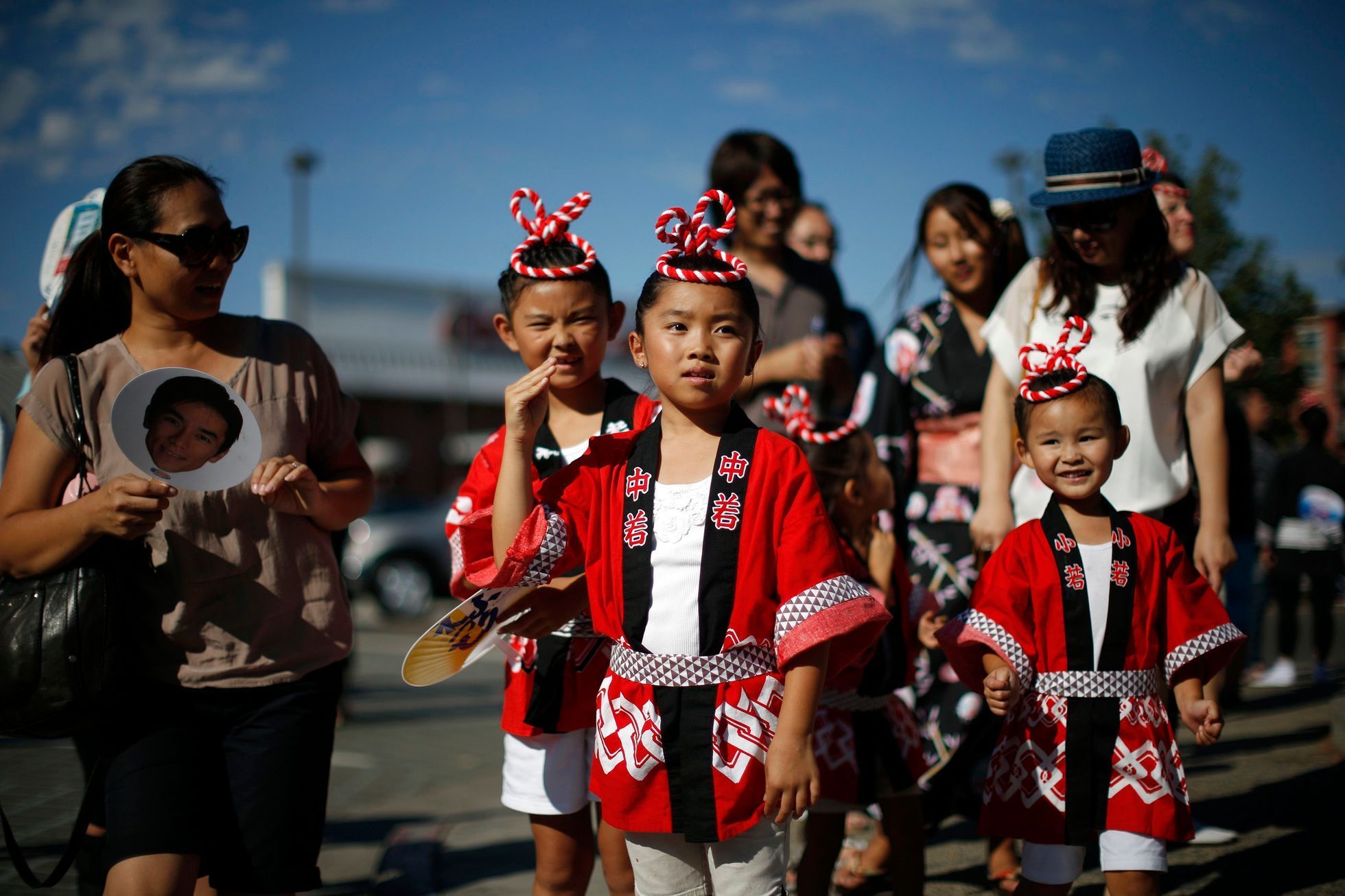 Children wave as they watch a parade in the Little Tokyo area of Los Angeles