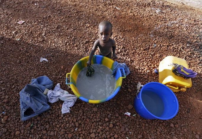 A child plays with water in a refugee camp in Sevare January 26, 2013. REUTERS/Eric Gaillard (MALI - Tags: CIVIL UNREST CONFLICT) Published: Led. 26, 2013, 6:19 odp.