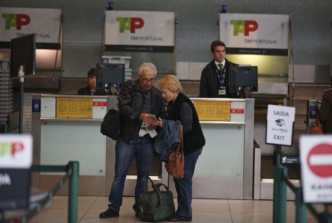 Passengers check their tickets at the airport during a 24-hour general strike in Lisbon November 14, 2012. Millions of workers joined strikes across southern Europe on Wednesday to protest against spending cuts and tax hikes that trade unions say have brought misery and deepened the region's economic crisis, with Spanish and Portuguese workers holding their first coordinated general strike. REUTERS/Rafael Marchante (PORTUGAL - Tags: BUSINESS POLITICS EMPLOYMENT TRANSPORT) Published: Lis. 14, 2012, 10:52 dop.