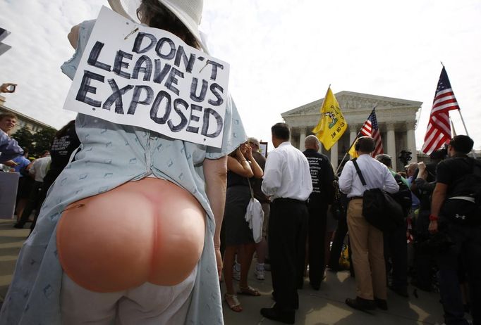 A supporter of U.S. President Barack Obama's 2010 healthcare overhaul stands outside the Supreme Court in Washington June 28, 2012. A sharply divided Supreme Court on Thursday upheld the centerpiece of Obama's signature healthcare overhaul law that requires that most Americans get insurance by 2014 or pay a financial penalty. REUTERS/Jason Reed (UNITED STATES - Tags: POLITICS HEALTH CIVIL UNREST TPX IMAGES OF THE DAY) Published: Čer. 28, 2012, 3:22 odp.