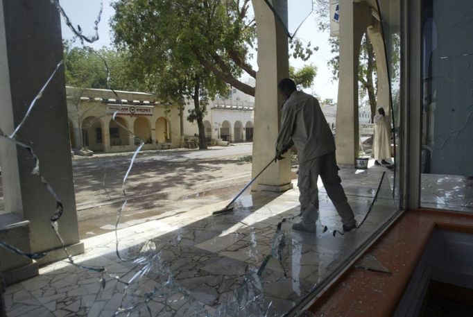 Prodavač uklízí před svým obchodem; odehrála se zde bitva mezi vládními vojáky a rebely. 7. února 2008