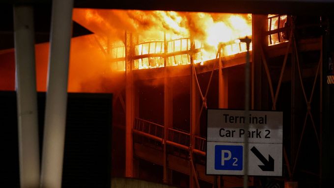Plameny šlehající z parkoviště na letišti Londýn Luton.