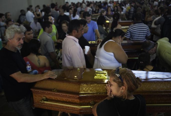 Relatives of victims of the fire at Boate Kiss nightclub attend a collective wake in the southern city of Santa Maria, 187 miles (301 km) west of the state capital Porto Alegre, January 27, 2013. The nightclub fire killed at least 232 people in Santa Maria early on Sunday when a band's pyrotechnics show set the building ablaze and fleeing partygoers stampeded toward blocked and overcrowded exits in the ensuing panic, officials said. REUTERS/Ricardo Moraes (BRAZIL - Tags: DISASTER OBITUARY) Published: Led. 27, 2013, 11:13 odp.