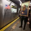 A participant in the Village Halloween Parade dressed as the Mona Lisa waits to ride the subway after the parade in the Manhattan borough of New York