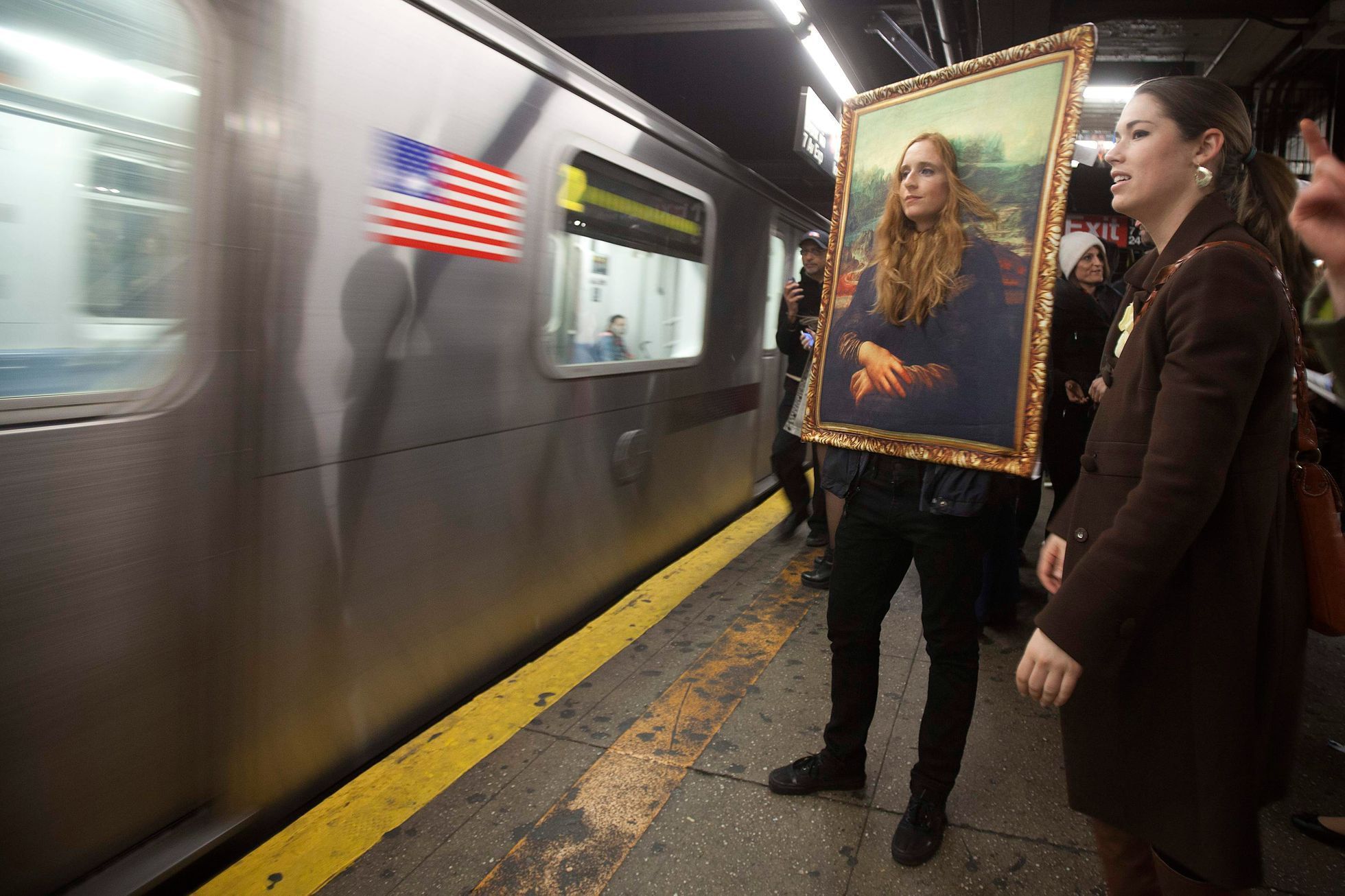 A participant in the Village Halloween Parade dressed as the Mona Lisa waits to ride the subway after the parade in the Manhattan borough of New York