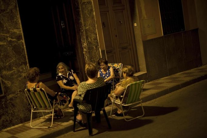 Women talk as they sit on chairs outside a house to avoid the heat on a hot summer night in Mancha Real, southern late Spain August 16, 2012. Picture taken August 16, 2012. REUTERS/Jon Nazca (SPAIN - Tags: SOCIETY) Published: Srp. 17, 2012, 7:37 dop.