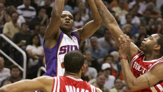 Hráč Phoenixu Suns Leandro Barbosa (v bílém) střílí přes hráče Houstonu Juwana Howarda (5) a Tracy McGradyho (vpravo).