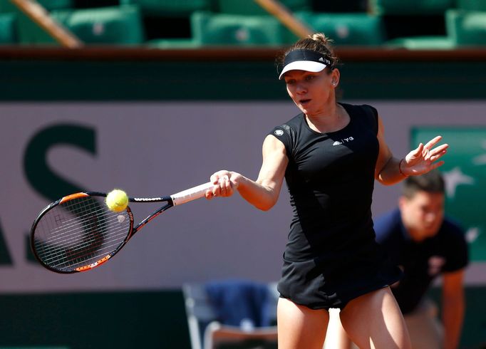 Simona Halep of Romania plays a shot to Evgeniya Rodina of Russia during their women's singles match at the French Open tennis tournament at the Roland Garros stadium in