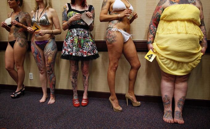 Keisha Holcomb (R), 31, from Fort Collins, Colorado, waits in line to have her tattoos judged in a contest during the National Tattoo Association Convention in Cincinnati, Ohio April 13, 2012. Holcomb, the product of a military family upbringing, was 16 when she got her first tattoo and is now a budding tattoo artist herself. She wants to have a full-body tattoo eventually, with the exception of her hands, throat and head. "Try to keep it classy", she says. Picture taken April 13, 2012. REUTERS/Larry Downing (UNITED STATES - Tags: SOCIETY) ATTENTION EDITORS PICTURE 19 OF 31 FOR PACKAGE 'ADDICTED TO THE NEEDLE' TO FIND ALL PICTURES SEARCH 'ADDICTED NEEDLE' Published: Čer. 29, 2012, 1 odp.