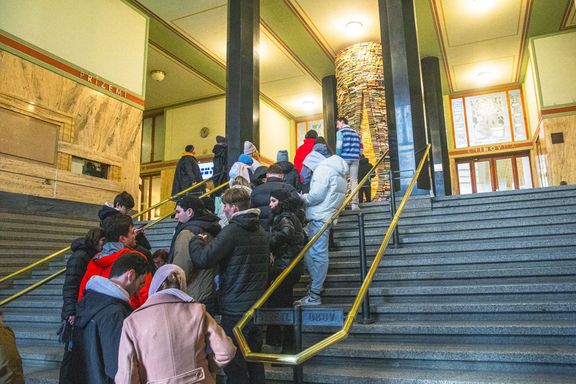Turisté čekají na schodech knihovny, aby si mohli udělat fotku.