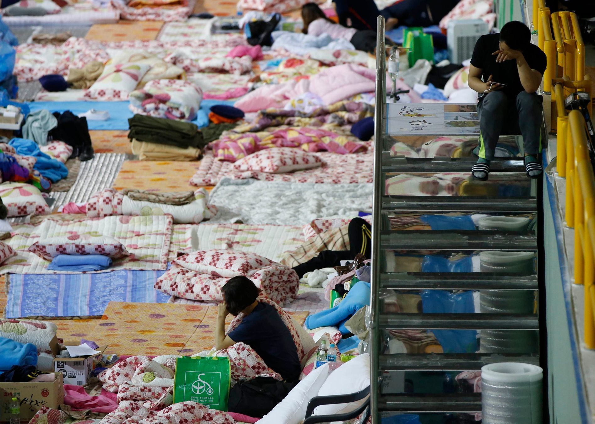 Family members of a missing passenger on board the capsized South Korean ferry Sewol rest as they wait for news from rescue and salvage teams in a makeshift accommodation at a gymnasium in the port ci