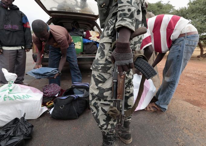 A Malian soldier inspects a car at a checkpoint in Thy, 15 km (9.3 miles) from Sevare January 27, 2013. REUTERS/Eric Gaillard (MALI - Tags: CIVIL UNREST CONFLICT MILITARY) Published: Led. 27, 2013, 12:51 odp.