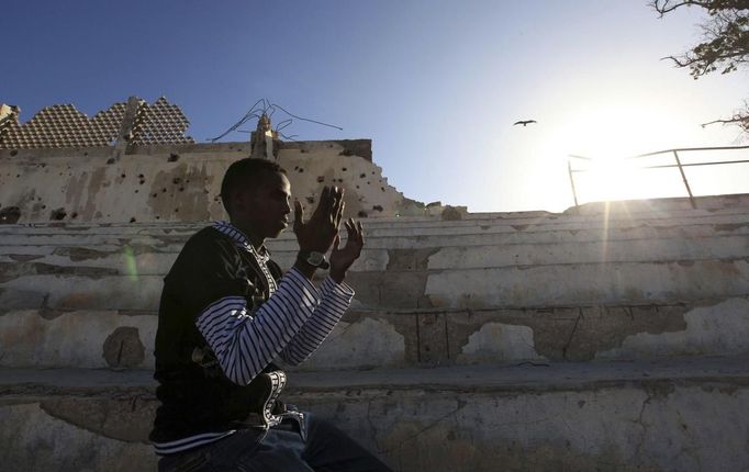 Somali athlete Abdullah Bare Kuulow prays after a training session during preparations for the 2012 London Olympic Games inside the stadium in Somalia's capital Mogadishu in this March 16, 2012 file photo. Training in a bullet-riddled stadium where the remains of a rocket propelled grenade lies discarded on the track's edge counts as progress for Somali Olympic hopeful Mohamed Hassan Mohamed. A year ago, Mogadishu's Konis stadium was a base for Islamist militants and a work out meant at times running through the streets, dodging gun-fire and mortar shells in one of the world's most dangerous cities. To match OLY-SOMALIA-HOPES/ REUTERS/Feisal Omar/Files (SOMALIA - Tags: SPORT ATHLETICS RELIGION SOCIETY OLYMPICS) Published: Čer. 11, 2012, 6:58 dop.