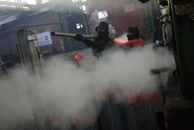 Coal miners hide behind shields, which read "miners", as they fire a home-made rocket during a clash with Spanish national riot police inside the "El Soton" coal mine in El Entrego, near Oviedo, northern Spain June 15, 2012. The miners were protesting against the government's proposal to decrease funding for coal production. REUTERS/Eloy Alonso (SPAIN - Tags: CIVIL UNREST BUSINESS EMPLOYMENT ENERGY) Published: Čer. 15, 2012, 11:52 dop.