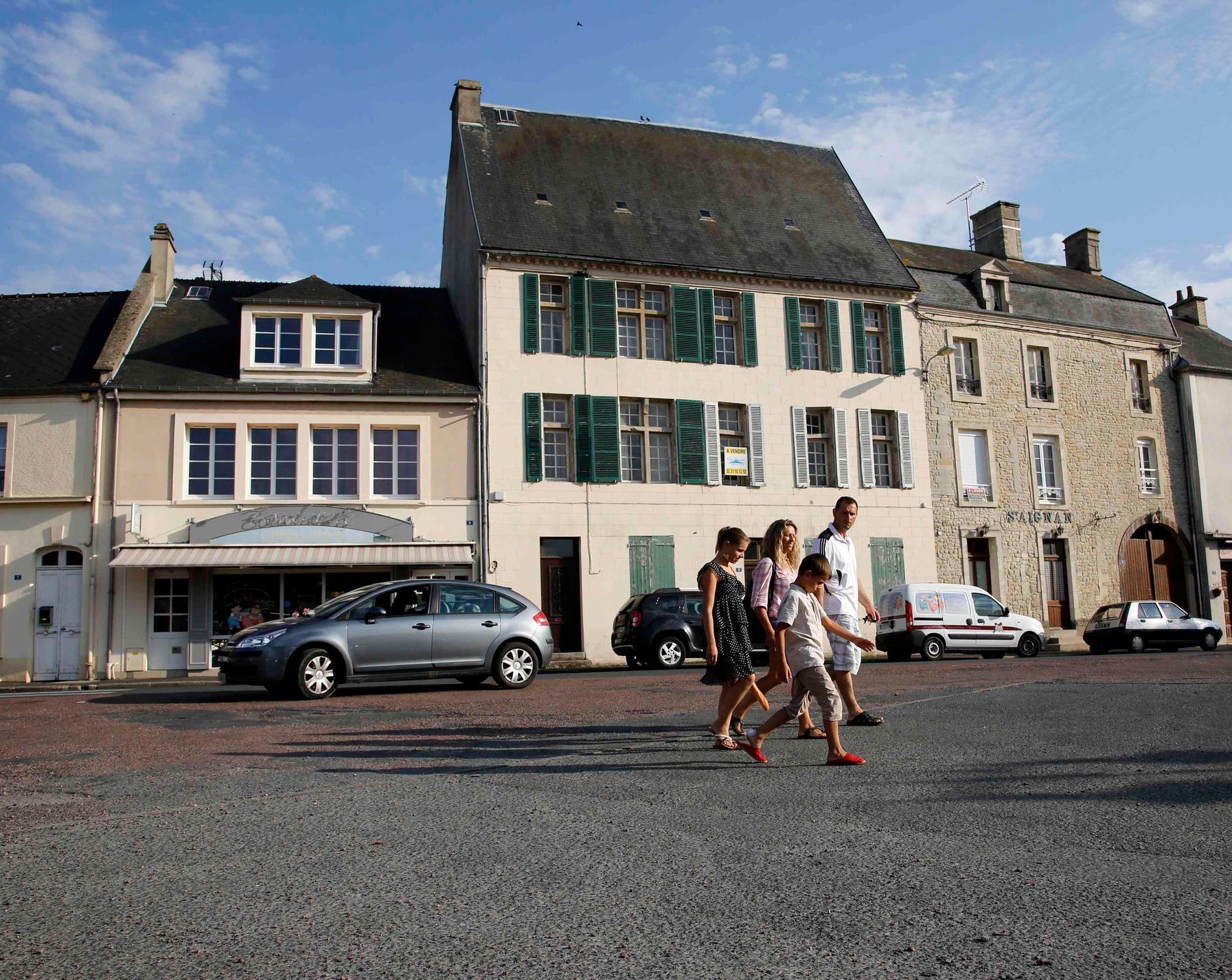 Tourists walk across the main square of Place Du Marche near the former D-Day landing zone of Omaha Beach