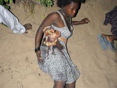 Žena zasažená šrapnely se ukrývá spolu s dalšími obyvately Maputa před létajícími částmi munice