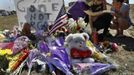 Isaac Pacheco (C) is comforted after leaving a birthday card for his friend Alex Sullivan, who was killed in the Denver-area movie killings, at a memorial site for victims behind the theater where a gunman opened fire on moviegoers in Aurora, Colorado July 21, 2012. A day after a gunman opened fire at a packed midnight showing of the new "Batman" film in a Denver suburb, killing 12 people and wounding 59 more, police on Saturday prepared to neutralize explosives in the suspect's booby-trapped apartment. The suspect, identified by police as James Eagan Holmes, 24, booby-trapped his Aurora apartment with sophisticated explosives, creating a hazard for law-enforcement and bomb squad officers who swarmed to the scene. REUTERS/Shannon Stapleton (UNITED STATES - Tags: ENTERTAINMENT CRIME LAW DISASTER SOCIETY TPX IMAGES OF THE DAY) Published: Čec. 21, 2012, 9:28 odp.