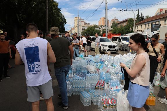 People who helped with the consequences of the attack on the hospital in Kyiv brought supplies of bottled water to the site due to the heat.