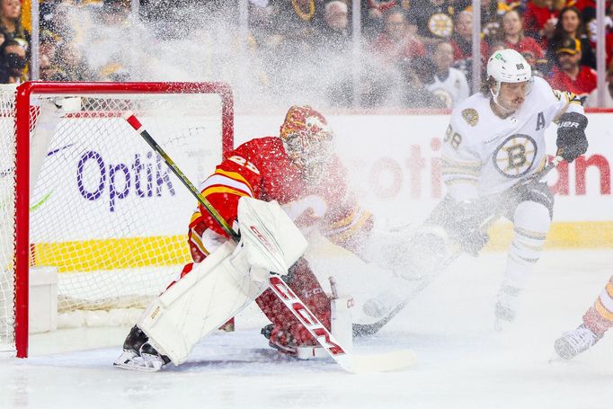 Brankář Calgary Jacob Markström a útočník Bostonu David Pastrňák v utkání, které Flames vyhráli 3:2 v prodloužení