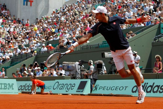 Srbský tenista Novak Djokovič doběhl míček v utkání se Slovincem Blazem Kavčičem ve 2. kole French Open 2012.