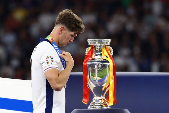 John Stones smutně prochází vedle trofeje pro vítěze po finále Eura 2024 Španělsko - Anglie