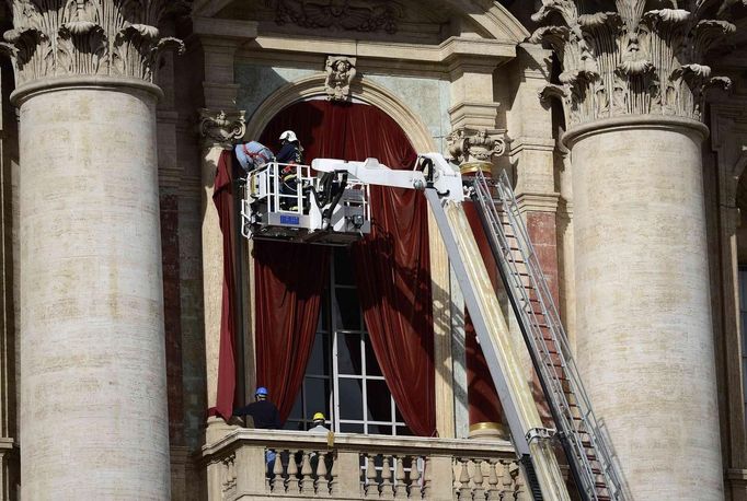 Workers put up a red curtain on the central balcony, called the Loggia of the Blessings of Saint Peter's Basilica at the Vatican March 11, 2013. After being elected in the conclave the new pope will appear on the balcony. REUTERS/Dylan Martinez (VATICAN - Tags: RELIGION) Published: Bře. 11, 2013, 10:10 dop.