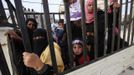 Relatives of Palestinian groom Emad al-Malalha ride in a pick up truck as they follow his car upon his arrival with his bride from a smuggling tunnel near the Gaza-Egypt border in the southern Gaza Strip March 21, 2013. Al-Malaha, 21, who said that his 17-year-old Egyptian bride Manal Abu Shanar was not given a permit from Egyptian authorities to enter the Gaza Strip, brought her from neighboring Egypt through a smuggling tunnel to celebrate his wedding in his native Gaza Strip. REUTERS/Ibraheem Abu Mustafa (GAZA - Tags: POLITICS SOCIETY) Published: Bře. 21, 2013, 6:40 odp.