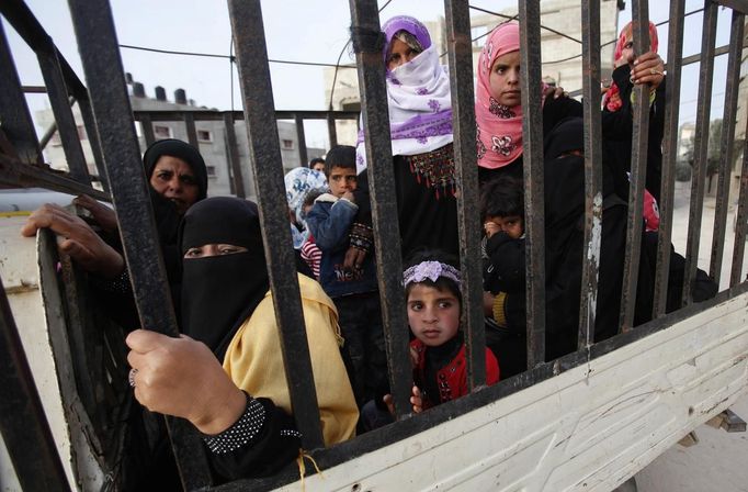 Relatives of Palestinian groom Emad al-Malalha ride in a pick up truck as they follow his car upon his arrival with his bride from a smuggling tunnel near the Gaza-Egypt border in the southern Gaza Strip March 21, 2013. Al-Malaha, 21, who said that his 17-year-old Egyptian bride Manal Abu Shanar was not given a permit from Egyptian authorities to enter the Gaza Strip, brought her from neighboring Egypt through a smuggling tunnel to celebrate his wedding in his native Gaza Strip. REUTERS/Ibraheem Abu Mustafa (GAZA - Tags: POLITICS SOCIETY) Published: Bře. 21, 2013, 6:40 odp.