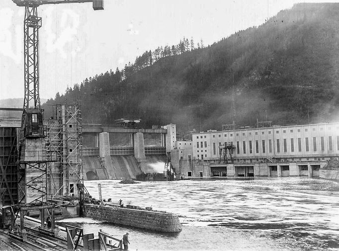 Historická fotografie zachycující výstavbu vodní nádrže Štěchovice, která probíhala mezi lety 1937 a 1944, navzdory válečným komplikacím.