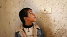 The brother of Palestinian boy Faris Basyoni, who was killed in an Israeli air strike, looks at his blood on a wall at his family's damaged house in Beit Hanoun in the northern Gaza Strip November 16, 2012. Basyoni was killed on Thursday night when an Israeli air strike hit his family house. Egypt opened a tiny window to emergency peace diplomacy in Gaza on Friday, but hopes for even a brief ceasefire while its prime minister was inside the bombarded enclave to talk to leaders of the Islamist Hamas movement were immediately dashed. REUTERS/Suhaib Salem (GAZA - Tags: CIVIL UNREST MILITARY POLITICS) Published: Lis. 16, 2012, 10:43 dop.