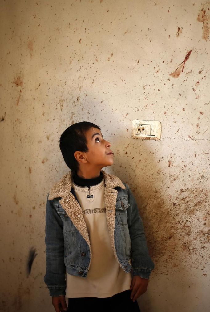 The brother of Palestinian boy Faris Basyoni, who was killed in an Israeli air strike, looks at his blood on a wall at his family's damaged house in Beit Hanoun in the northern Gaza Strip November 16, 2012. Basyoni was killed on Thursday night when an Israeli air strike hit his family house. Egypt opened a tiny window to emergency peace diplomacy in Gaza on Friday, but hopes for even a brief ceasefire while its prime minister was inside the bombarded enclave to talk to leaders of the Islamist Hamas movement were immediately dashed. REUTERS/Suhaib Salem (GAZA - Tags: CIVIL UNREST MILITARY POLITICS) Published: Lis. 16, 2012, 10:43 dop.