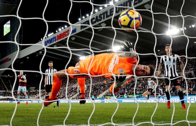 Brankář Karl Darlow z Newcastlu United se marně natahuje po míči z kopačky hráče Burnley Sama Vokese.