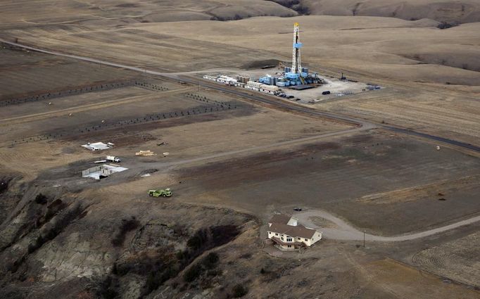 An oil drilling rig operates near homes and farm fields outside Williston, North Dakota, October 19, 2012. Thousands of people have flooded into North Dakota to work in state's oil drilling boom. Picture taken October 19, 2012. REUTERS/Jim Urquhart (UNITED STATES - Tags: ENERGY ENVIRONMENT AGRICULTURE BUSINESS EMPLOYMENT) Published: Říj. 22, 2012, 1:40 odp.