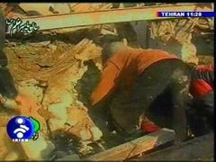 Záchranáři vyprošťují raněné z trosek domu. Záběr íránské televize.