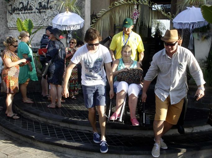 A survivor of the 2002 Bali bomb blast is helped by her family as they arrive for the commemoration service for the 10th anniversary of the Bali bombing in Garuda Wisnu Kencana (GWK) cultural park in Jimbaran, Bali October 12, 2012. Indonesian police have warned of possible attacks on commemorations for the tenth anniversary of bomb blasts on the island of Bali and have brought in reinforcements to protect the thousands due to attend, including Australia's prime minister. REUTERS/Murdani Usman (INDONESIA - Tags: ANNIVERSARY POLITICS) Published: Říj. 12, 2012, 3:37 dop.