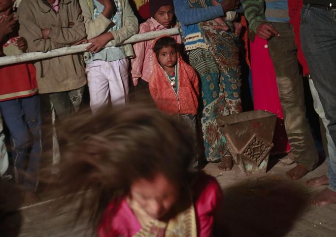 People watch a devotee who is believed to be possessed by evil spirits dance in a state of trance at Guru Deoji Maharaj temple during a ghost fair at Malajpur village in Betul district in the central Indian state of Madhya Pradesh January 27, 2013. People from across India come to this fair to be exorcised of �evil spirits�. They are usually brought by relatives and they are most often women. The exorcism involves running around the temple courtyard to make the 'ghost' weak then being beaten by a priest with a broom. Picture taken January 27, 2013. REUTERS/Danish Siddiqui (INDIA - Tags: SOCIETY RELIGION) ATTENTION EDITORS: PICTURE 23 OF 24 FOR PACKAGE 'INDIAN GHOSTBUSTERS' SEARCH 'INDIA GHOST' FOR ALL IMAGES Published: Úno. 5, 2013, 5:10 dop.