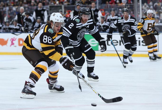 Winter Classic NHL 2019, Chicago - Boston: David Pastrňák ujíždí s pukem Duncanu Keithovi.