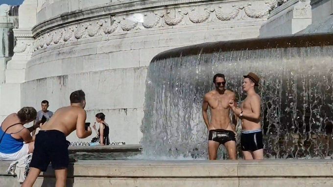 Záběry na muže, kteří se obnažení koupali ve fontáně.