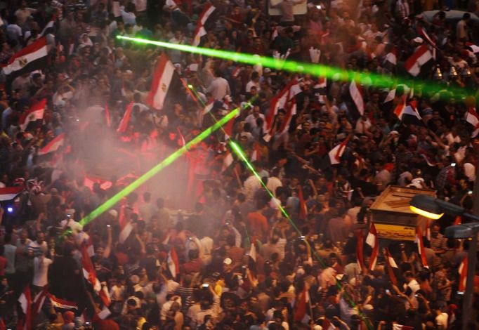 Laser lights are flashed as protesters against Egyptian President Mohamed Mursi gather in Tahrir Square in Cairo July 3, 2013. Egypt's armed forces and Islamist President Mohamed Mursi refused to back down on Wednesday as a deadline for a military takeover passed with rival demonstrators out in force in the streets of Cairo. REUTERS/Asmaa Waguih (EGYPT - Tags: POLITICS CIVIL UNREST) Published: Čec. 3, 2013, 6:27 odp.