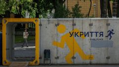 Woman passes by a street bomb shelter next to a bus stop in Dnipro