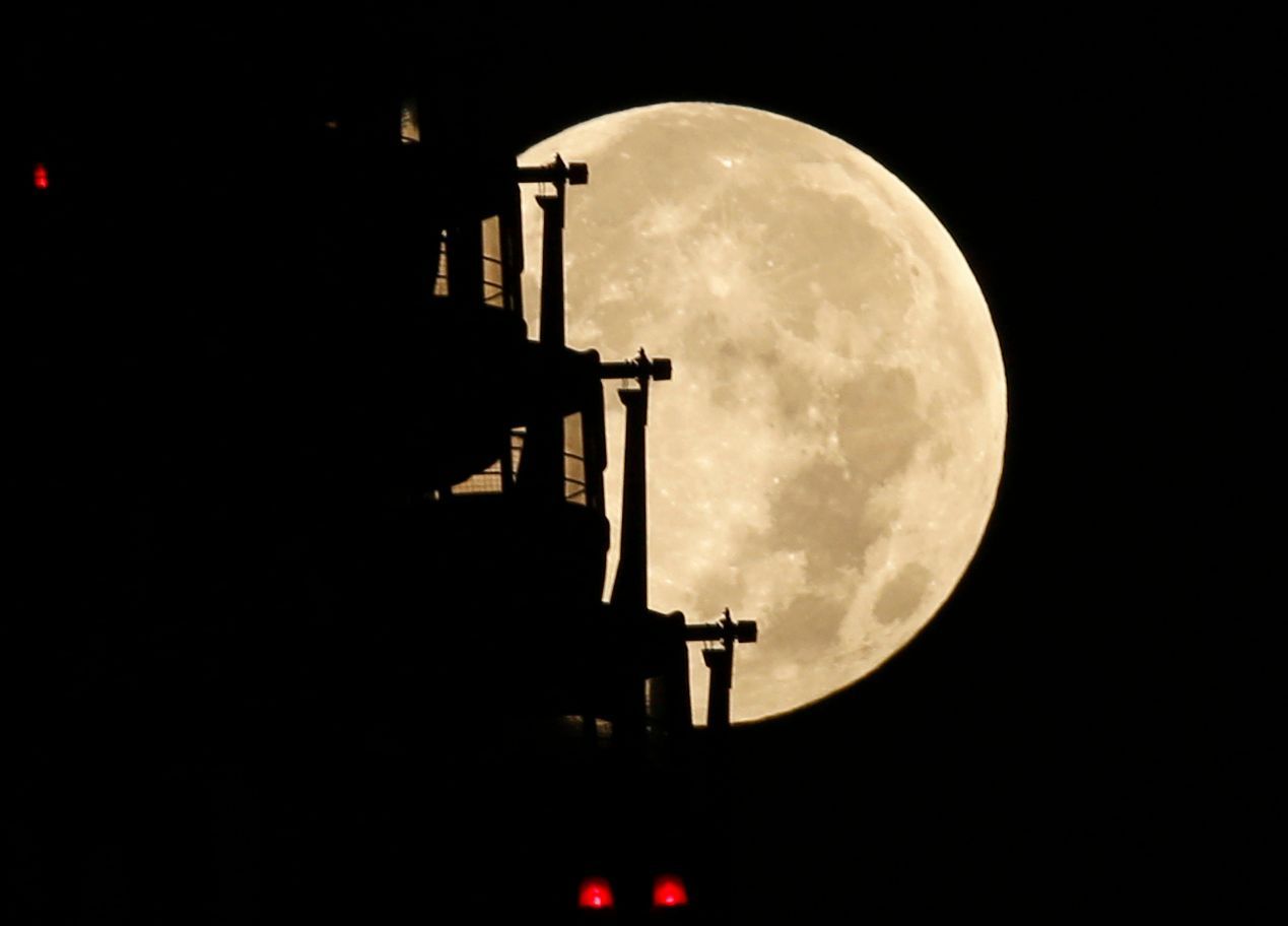 The supermoon is seen behind a ferris wheel in Tokyo