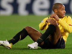 Útočník Arsenalu Londýn Thierry Henry sedí na trávníku během utkání s Juventusem.