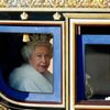 Královna Alžběta II. vyhlíží ze svého kočáru