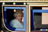 Královna Alžběta II. vyhlíží ze svého kočáru cestou z Buckinghamského paláce do paláce Westminsterského