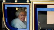 Královna Alžběta II. vyhlíží ze svého kočáru cestou z Buckinghamského paláce do paláce Westminsterského