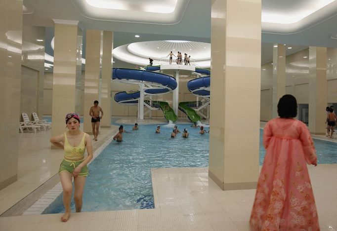 RNPS IMAGES OF THE YEAR 2012 - A woman in traditional Korean costume watches as a student leaves a swimming pool of Kim Il-sung University in Pyongyang April 11, 2012. REUTERS/Bobby Yip (NORTH KOREA - Tags: EDUCATION SOCIETY) Published: Pro. 3, 2012, 1:26 dop.