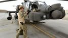 Britain's Prince Harry stands by an Apache helicopter in Camp Bastion, southern Afghanistan in this photograph taken October 31, 2012, and released January 21, 2013. The Prince, who is serving as a pilot/gunner with 662 Squadron Army Air Corps, is on a posting to Afghanistan that runs from September 2012 to January 2013. Photograph taken October 31, 2012. Photograph pixelated at source. REUTERS/John Stillwell/Pool (AFGHANISTAN - Tags: MILITARY POLITICS SOCIETY ROYALS CONFLICT) Published: Led. 21, 2013, 7:39 odp.